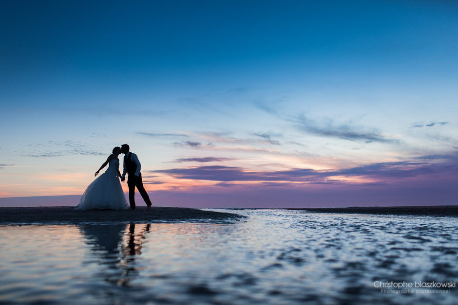 Reflet de couple dans un lac / mer pour une photo de mariage créative