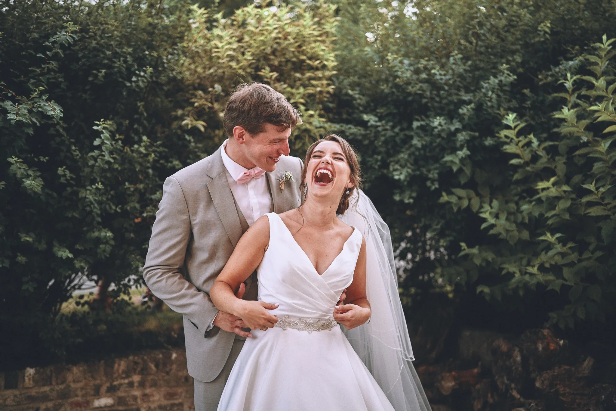 Les mariés de Frévent éclatant de rire au Château de Morbecque. Photo de mariage par Christophe Blaszkowski, Photographe lillois pour vos moments inoubliables