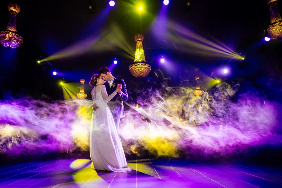Première danse des mariés dans une ambiance féerique, entourés de fumée et de lumières, créant une atmosphère hors du temps.Photographe expert dans la capture de moments magiques