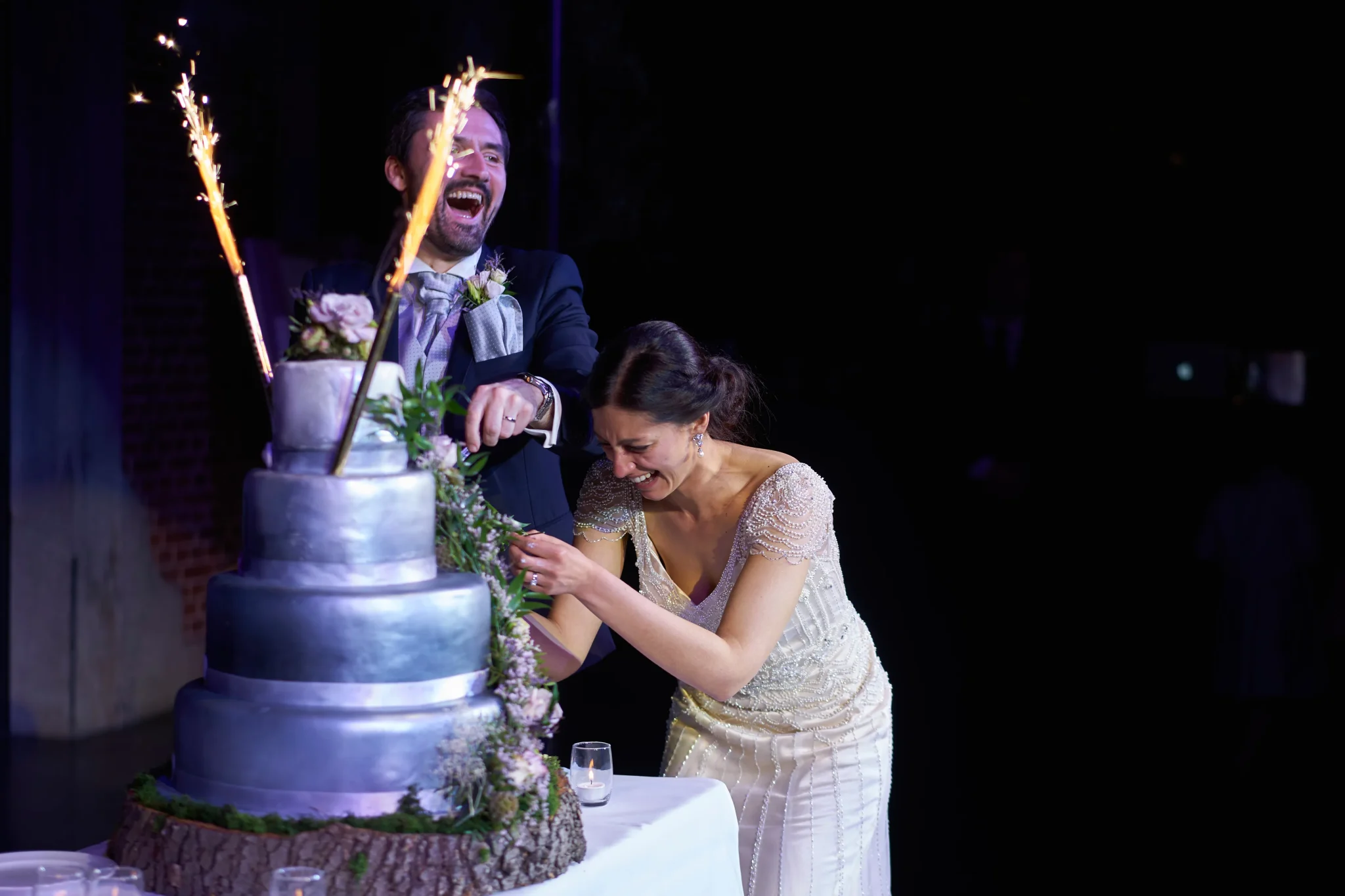 Photo des mariés venant de Reims éclatant de rire lors de la découpe du wedding cake au Château du Biez à Pecq. Photographe spécialisé dans les mariages lillois.
