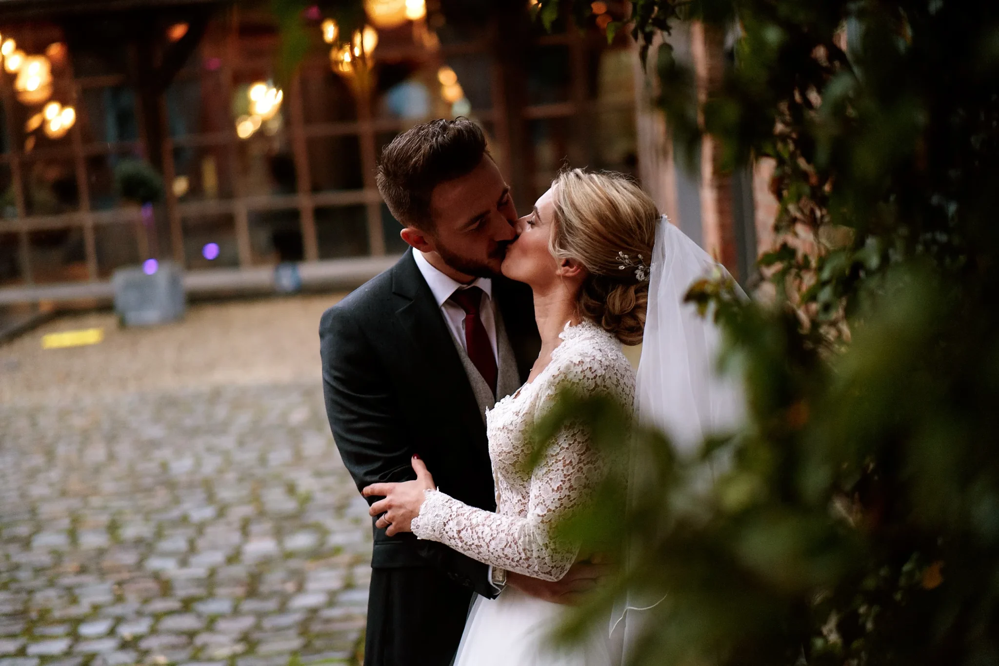 Mariés de Perenchies s'embrassant dans un cours pavé près de Verlinghem, photo de couple romantique lors de leur mariage