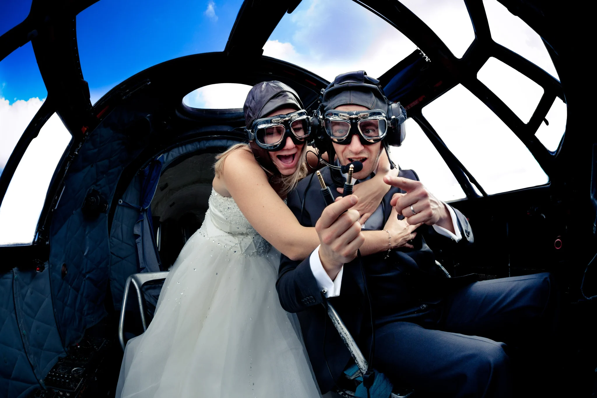 Photo de couple après mariage dans le cockpit d’un avion avec câbles arrachés – mise en scène drôle avec lunettes d’aviateur et casque, prise à Lille ou dans une ville du Nord. Les mariés sont de Roye (80) | Somme